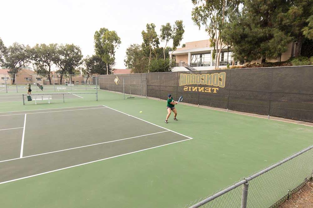 Tennis players practice on the courts at Concordia.